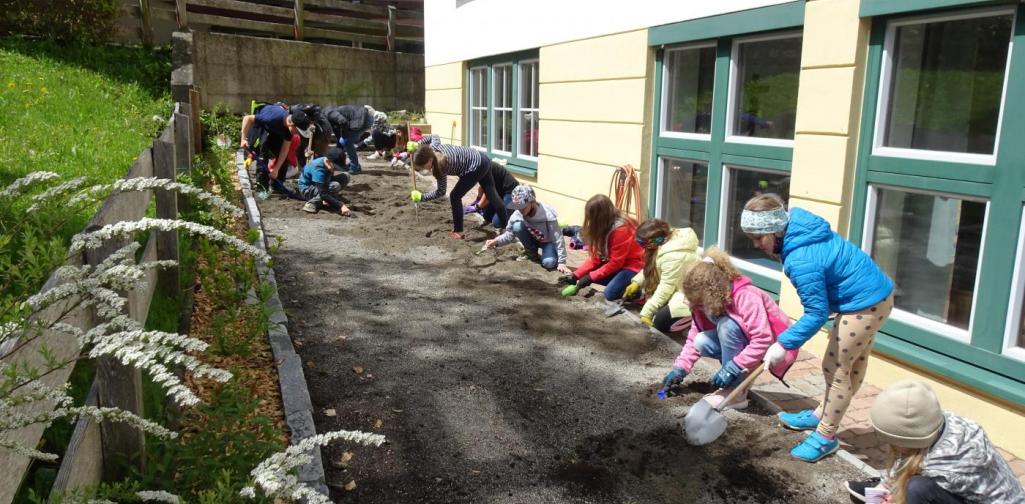 Die Kinder mischen den Sand mit der Erde
